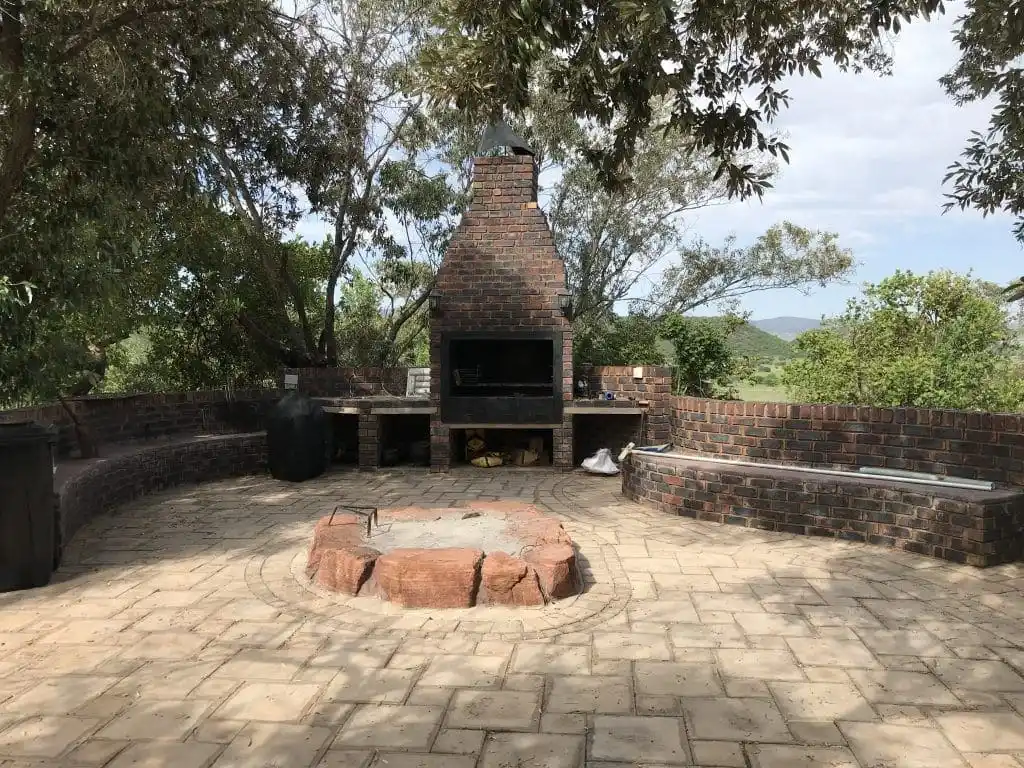 Zona exterior con braai tradicional, espacio perfecto para reuniones al aire libre rodeado de naturaleza.